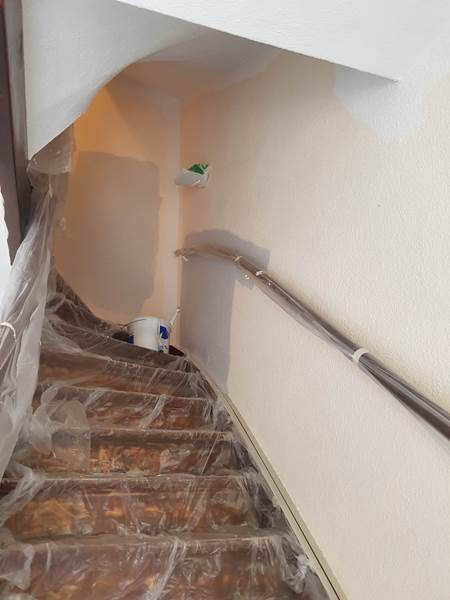 Treppenhaus während der Renovierung – Wände gespachtelt, Stufen mit Folie abgedeckt